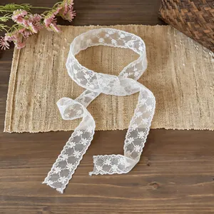Close-up view of a delicate white floral lace ribbon scarf used as hair band or necktie