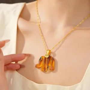 Close-up of bohemian style elephant pendant necklace with unique tiger-eye resin pattern