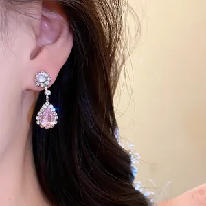 Detailed view of sparkling pink teardrop zircon earring worn on ear for elegant style.