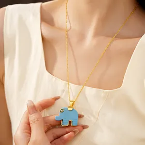 Detailed view of a blue resin elephant pendant necklace on a golden chain, worn by a model