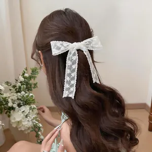 Elegant white floral lace ribbon hair accessory styled as a bow on long wavy hair