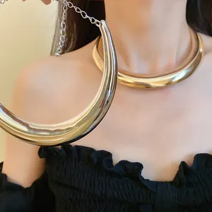 Dettaglio della finitura metallica lucida di una collana girocollo a mezzaluna