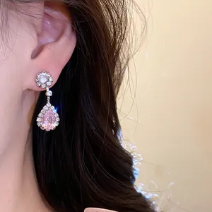 Close-up detail of exquisite pink waterdrop zircon dangling earrings worn by a model