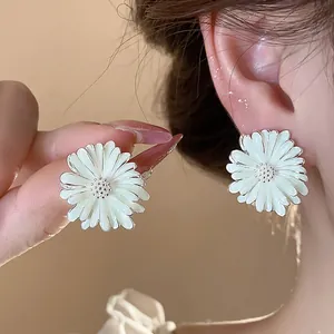 Dettaglio di orecchini a margherita in smalto bianco con perni in argento sterling.