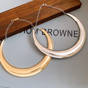Vista dettagliata di collane torque in metallo lucido color oro e argento per donna