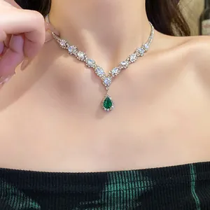 Macro view of an elegant teardrop emerald pendant necklace with brilliant zirconia accents