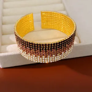 Primo piano di un bracciale elastico multistrato con strass sfumati in finitura oro