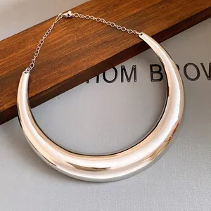 Dettaglio ravvicinato di un choker in metallo argento lucido dal design minimalista