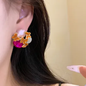 Vintage butterfly stud earrings with pink oval gemstone on an Asian female model ear