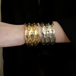 Vintage gold and silver wavy textured metal cuff bracelet with a premium minimalist design