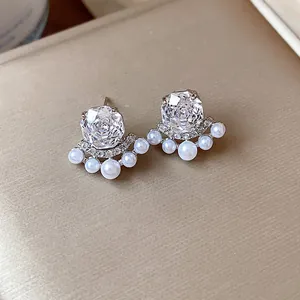 Detailed view of elegant zircon earrings with small pearls and sparkling micro-insets