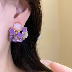 Vintage sweet purple butterfly stud earrings with crystals shown worn on the ear detail shot
