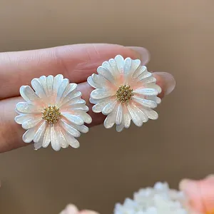Dettaglio dei petali perlati e del centro dorato lucido degli orecchini a margherita