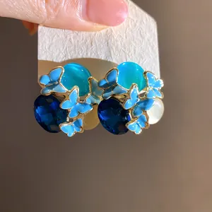 Close-up detail of vintage blue butterfly earrings with faceted stones and silver needles