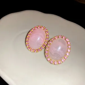 Detailed view of vintage oval stud earrings with pink marble acrylic and rhinestones