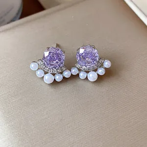 Detailed view of French style purple zircon flower earrings with delicate white pearls.