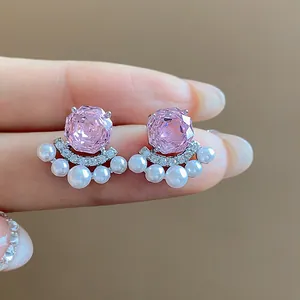 Exquisite close-up of pink zircon and white pearl stud earrings with fine details