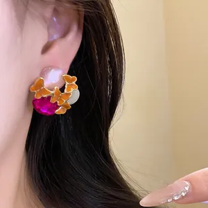 Close-up detail of vintage butterfly stud earrings with pink crystal and enamel