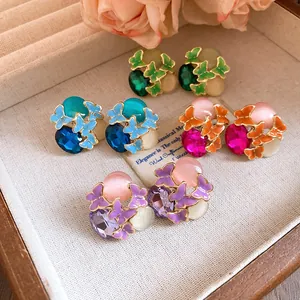 Close-up of colorful butterfly stud earrings with gemstones and enamel in a jewelry box.