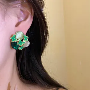 Close-up of vintage green butterfly stud earring with drop oil and gemstone details
