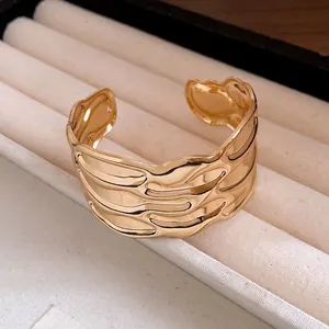 Detailed macro view of a vintage gold wavy textured open cuff bracelet in a jewelry tray.