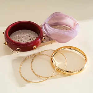 Detailed view showing a 4-piece set of vintage resin and polished gold-tone metal bangles