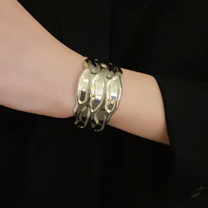 Detail view of a vintage silver-toned textured metal open cuff bracelet on wrist.