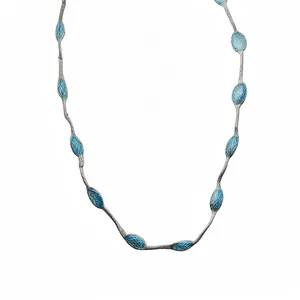 Elegante zilveren ketting met levendige blauwe ovale bedels aan een fijne ketting.