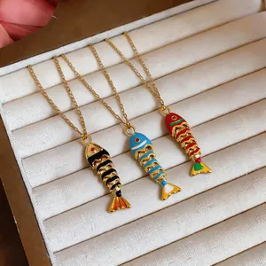 Primo piano di ciondoli a forma di pesce in smalto colorato in un elegante portagioie