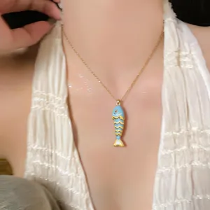 Primo piano di una collana con ciondolo a forma di pesce blu smaltato in acciaio inossidabile.