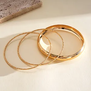 Close-up of 4-piece vintage gold bracelet set with smooth and textured finishes.