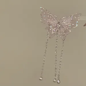Elegante dettaglio di un fermaglio per capelli a farfalla rosa con nappe di cristallo