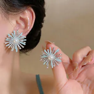 Elegant fireworks shaped stud earrings featuring blue enamel petals and shimmering pearls
