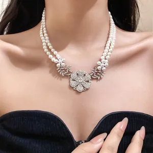 Close-up of elegant double-strand pearl necklace with sparkling rhinestone flower