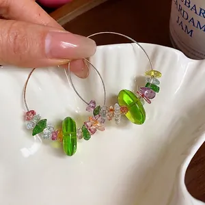 Élégantes créoles avec perles en résine verte et pierres colorées pour femmes actives.