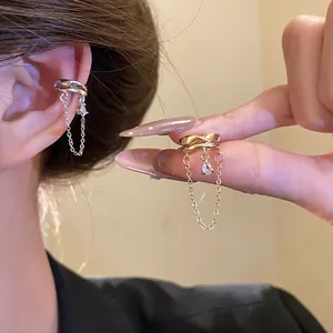Close-up of 18k gold plated ear cuff with zircon pendant and elegant chain detail