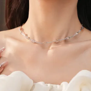 Gedetailleerde close-up van een zilveren choker met elegante gaasvormige kralen op een model.