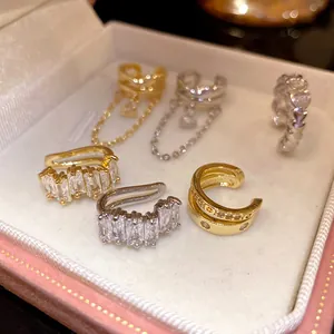 Detailed shot of various 18k gold and silver plated zircon ear cuffs in a pink jewelry gift box