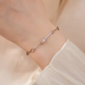 Gedetailleerd overzicht van een elegante gouden mesh armband met gekleurde zirkoon om de pols.