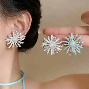 Detailed view of starburst zircon earrings with central pearl and enamel detail