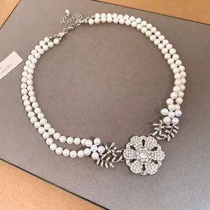 Elegant double-strand pearl necklace featuring a sparkling rhinestone flower pendant