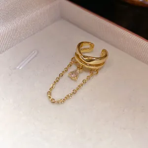 Macro view of 18k gold plated ear cuff featuring dangling chain and teardrop zircon