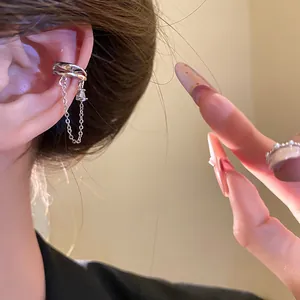 Macro detail view of 18k gold plated silver heart ear cuff with dangling chain and zircon