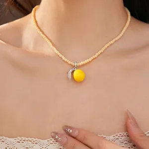 Collar de cuentas con colgante de limón de resina y detalle de hoja de circón