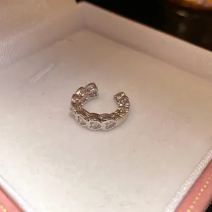 Close-up of elegant silver heart zircon ear cuff displayed in a jewelry gift box