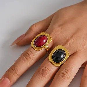 Primer plano de anillos vintage dorados con piedras ovaladas rojas y negras