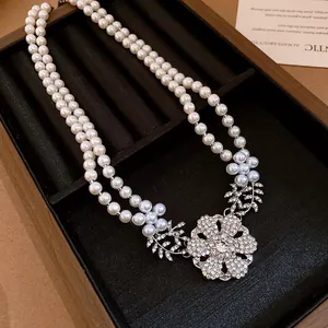 Detailed view of elegant double-layer pearl necklace with a sparkling rhinestone flower
