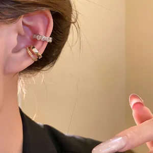 Detailed macro view of an 18k gold plated heart zircon ear cuff set worn on a model's ear
