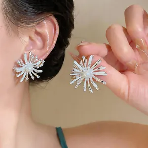 Elegant firework-shaped silver stud earrings with pearls and zircons shown on a model