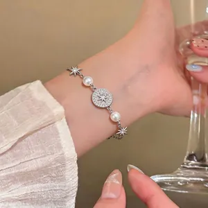 Bellissimo bracciale placcato oro 14k con stelle di zircone e perle su un polso